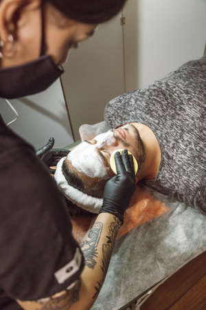 man receiving a facial in a beauty salonの写真素材