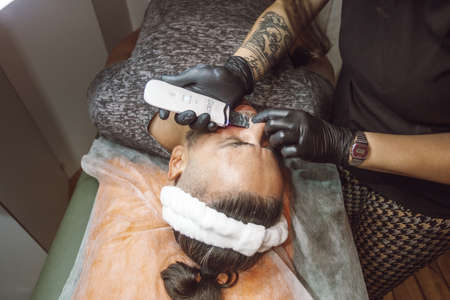 man receiving a facial in a beauty salonの写真素材