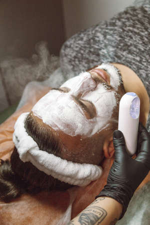 man receiving a facial in a beauty salonの写真素材