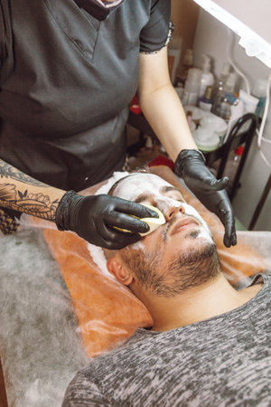 man receiving a facial in a beauty salonの写真素材