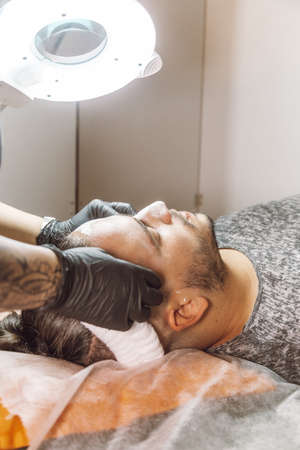 man receiving a facial in a beauty salonの写真素材