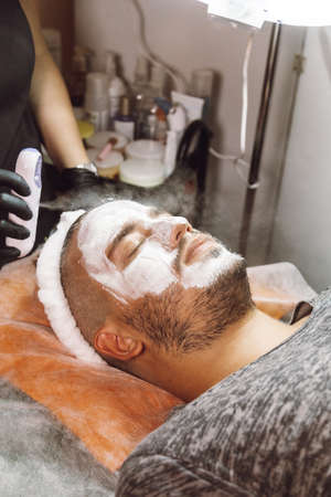 man receiving a facial in a beauty salonの写真素材