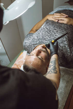 man receiving a facial in a beauty salonの写真素材