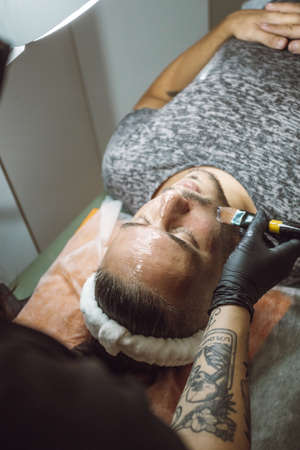 man receiving a facial in a beauty salonの写真素材
