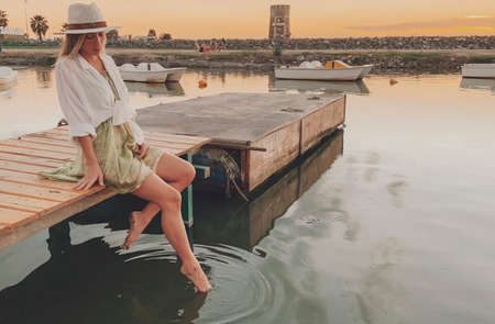 woman staring at a sunset by the lakeの写真素材