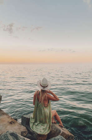 woman staring at a sunset by the lakeの写真素材