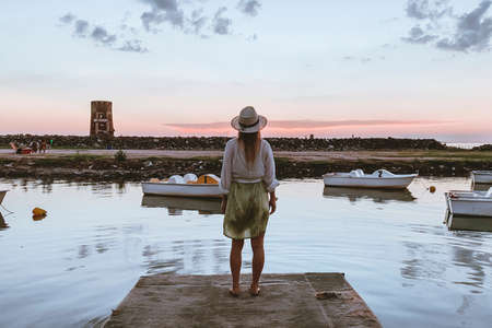 woman staring at a sunset by the lakeの写真素材