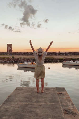 woman staring at a sunset by the lakeの写真素材