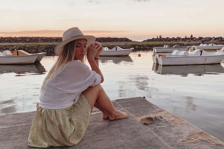 woman staring at a sunset by the lakeの写真素材