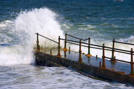 Waves of the sea hitting about quay in storm weather