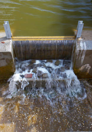 Dam of lake with a flowing water in a sunny dayの写真素材