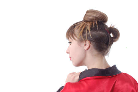 attractive girl in red kimono stay to turn the head backward. isolated over white. whith copyspaceの写真素材