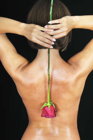 girl hold rose on  back. black backgroundの写真素材