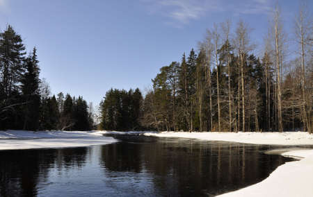 A river in Sweden surrounded by snow in springの写真素材