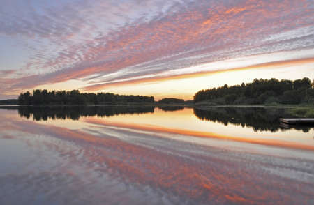 Calm lake reflection at sunsetの写真素材