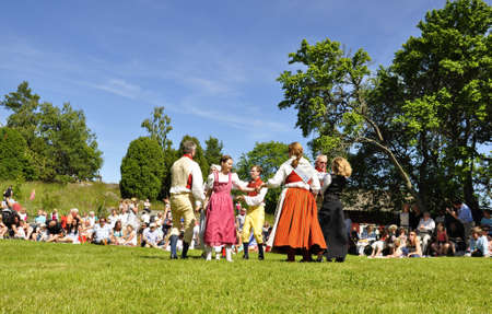 Torsstuna, Sweden-June 22: Folklore ensemble of Sweden in traditional folk costyme perform a dance in midsummer day on June 22, 2012 in torstuna, Sweden.のeditorial素材