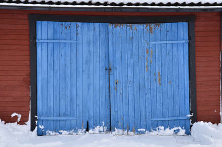 Red house with blue doors in winterの写真素材