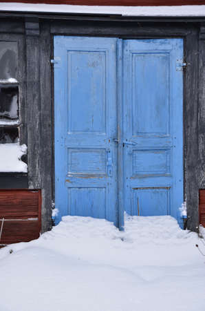 Red house with blue doors in winterの写真素材