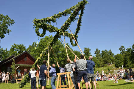Torstuna, Sweden - June 21: People take care of maypole in midsummer event on June 21, 2013 in Torstuna Swedenのeditorial素材
