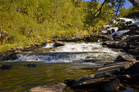 Frothy mountain stream through bouldersの写真素材