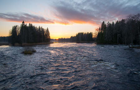 Scenic view of a flowing river in sunsetの写真素材
