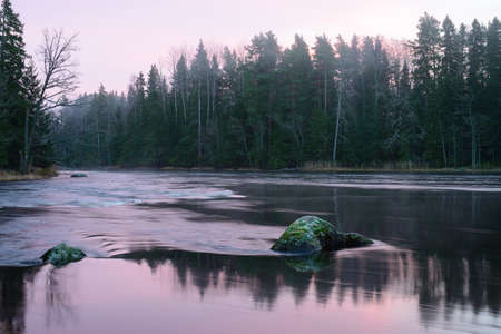 Midwinter light over flowing river landscape before the sunriseの写真素材
