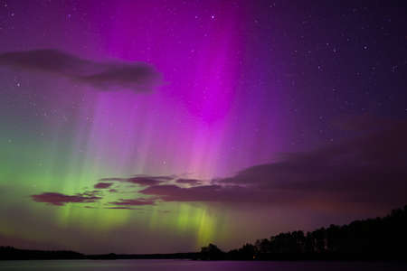 Scenic view of northern lights over lake (Aurora borealis)の写真素材