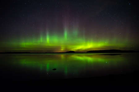 Northern lights over calm lake Aurora borealisの写真素材