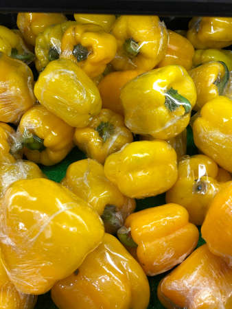 Lot of yellow bell pepper in plastic wrap. Selective focus.の写真素材