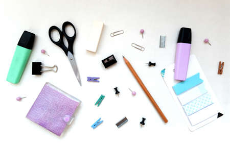 Flatlay stationery composition, writing objects in random order scissors, marker, notepad, paperclip, eraser, pencil, stickers, top view, office and back to school conceptの写真素材