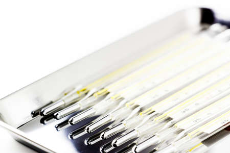 many mercury clinical thermometers in the metal trayの写真素材