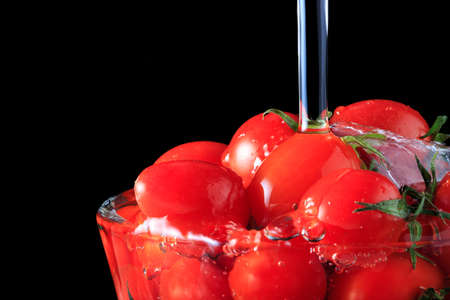 many tomato in the glass bowl with waterの写真素材