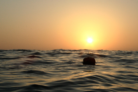 Buoy floating at sunsetの写真素材