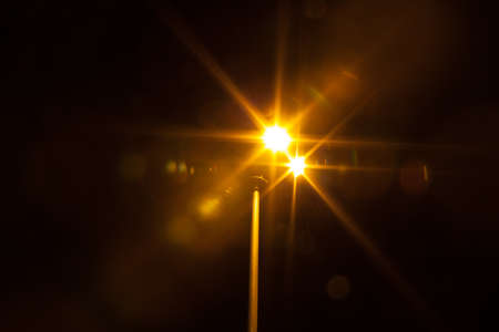 spotlights with orange beams on dark background の写真素材