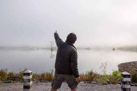 A man stand and look around the view side of foggy dams early morning の写真素材
