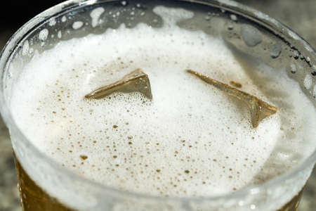 cold beer with ice in Disposable Cupの写真素材