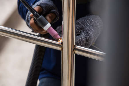 Welder working a welding metal with protective mask and sparks.の写真素材