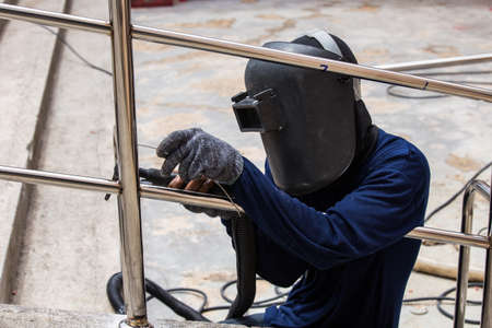 Welder working a welding metal with protective mask and sparks.の写真素材