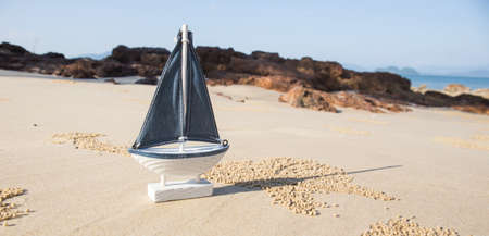 wooden sail ship toy model in the sea sand.の写真素材