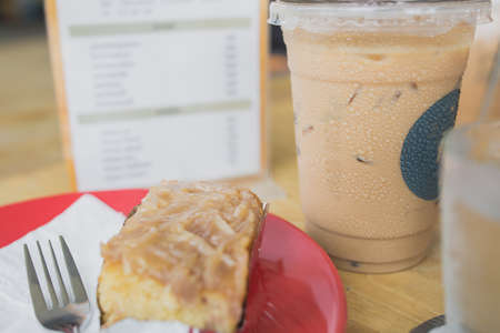 a latte coffee and cake on red disk.の写真素材