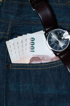 Card and  Thai banknotes in a back pocket of a denim jean.の写真素材