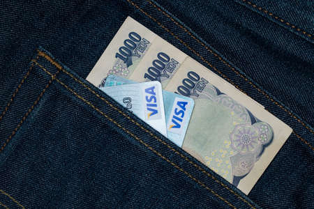 Card and  Japanese yen currency bank note in a back pocket of a denim jean.の写真素材