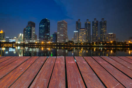 wooden floor and Blured business district and reflection building.の写真素材