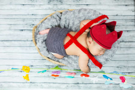 Cute baby boy sleeping in a basket.の写真素材