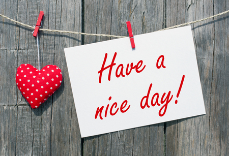Have a nice day - red heart with postcard on wooden backgroundの写真素材