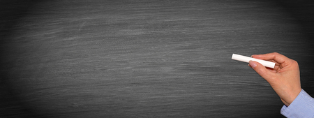 Female hand with chalk on horizontal chalkboard background texture - copy space for individual textの写真素材
