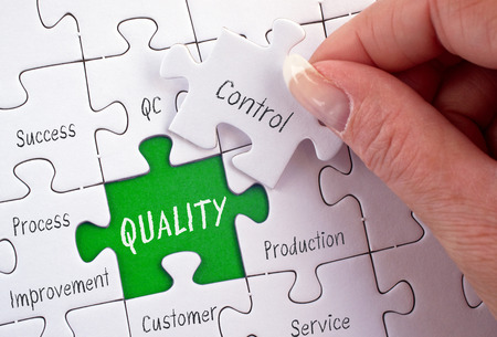 Quality Control - female hand with business puzzleの写真素材