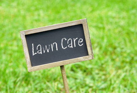 Lawn Care - chalkboard on green grass backgroundの写真素材