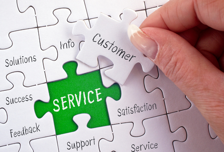 Service - business concept puzzle with female hand and textの写真素材
