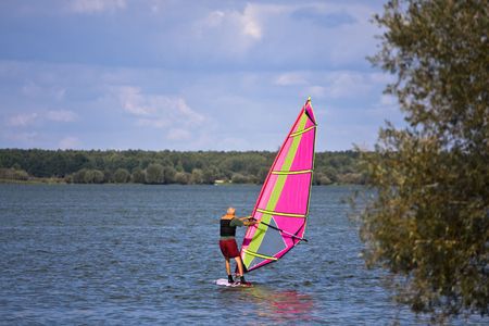 Man learning how to surf on the quiet lakeの写真素材